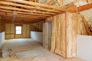 Loft insulation rolls being installed in a UK attic to reduce energy bills and improve home efficiency